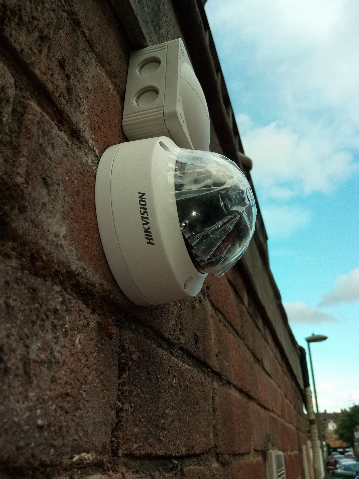 Hikvision dome camera installed on commercial building exterior wall